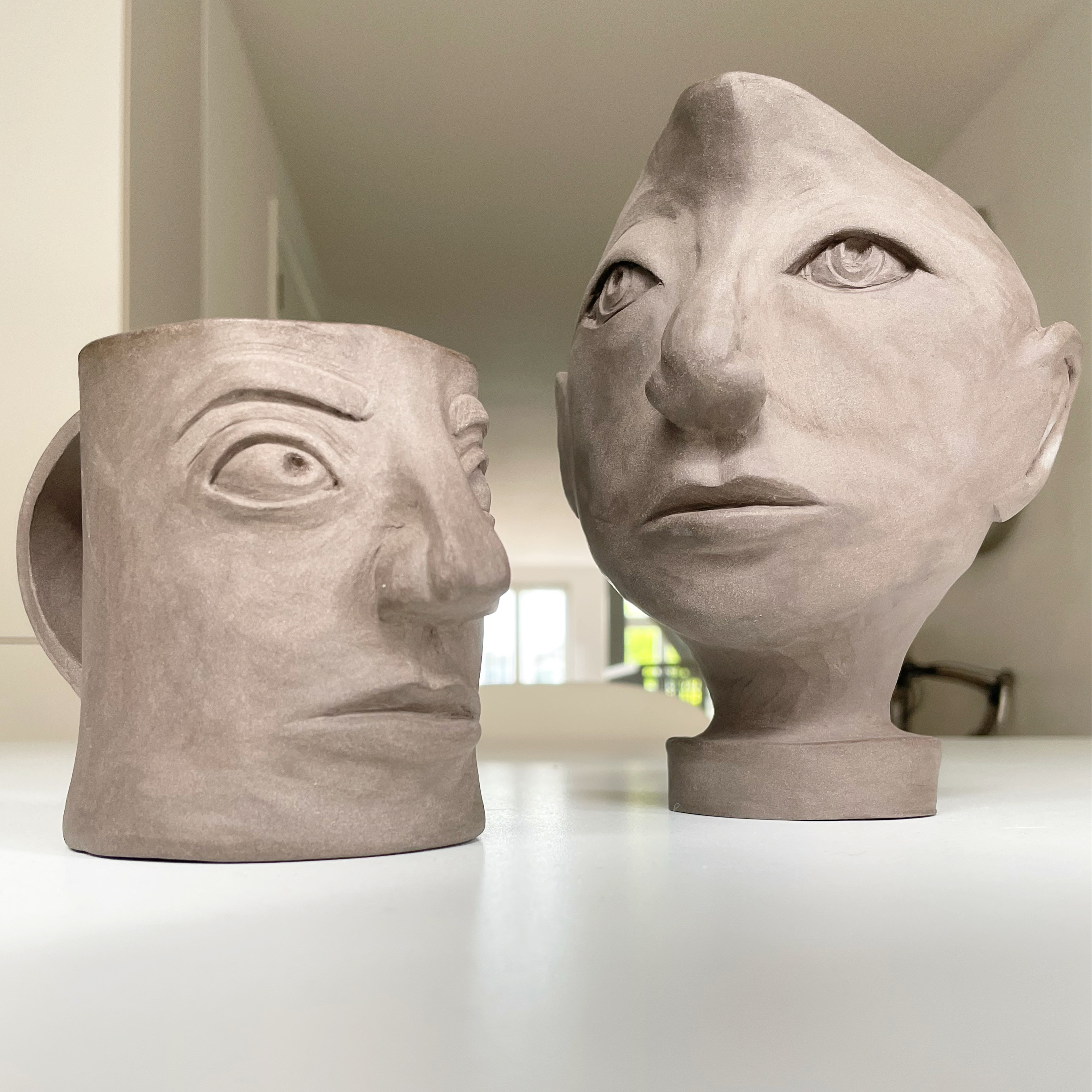 A mug and a pitcher, both with faces