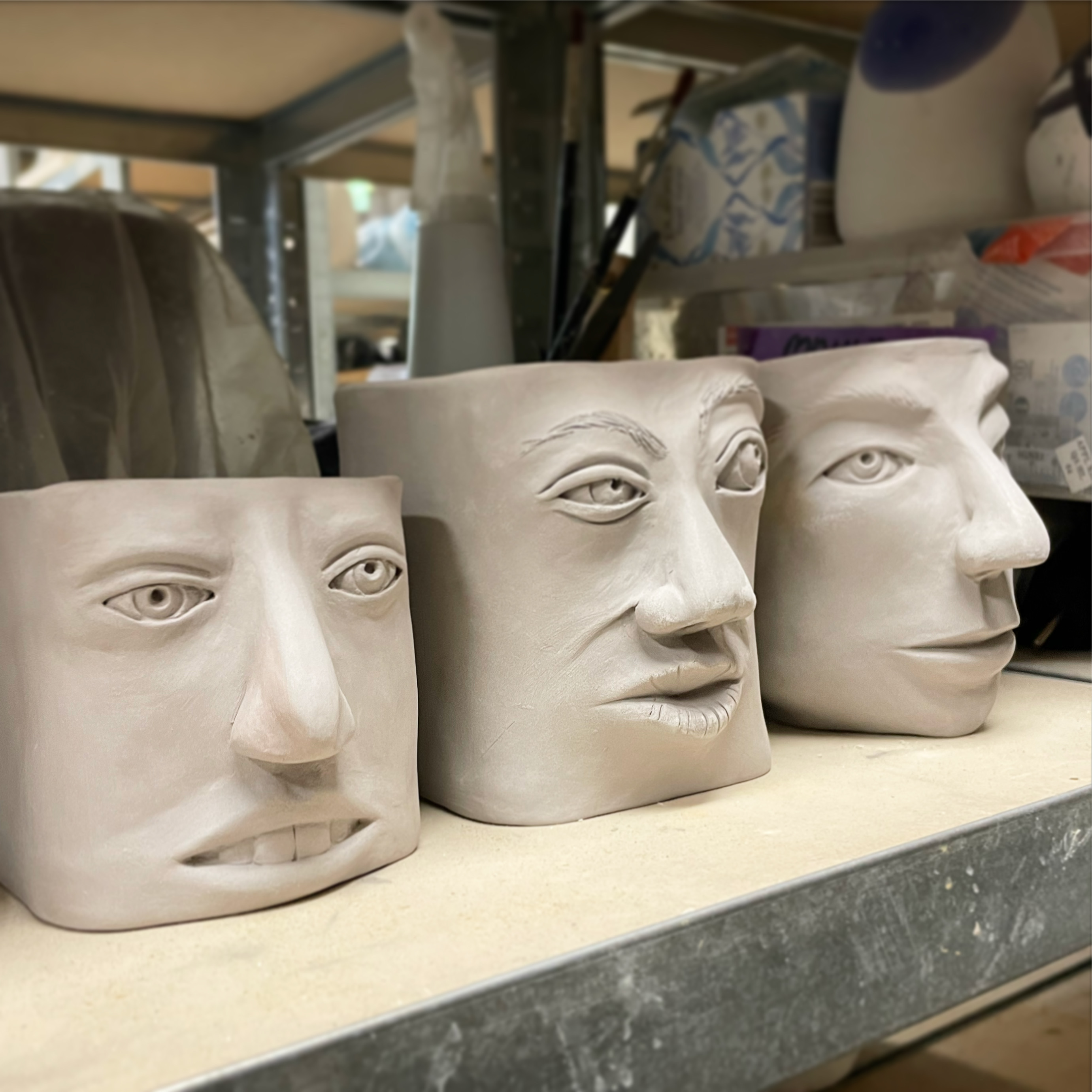 Three vessels, all with faces