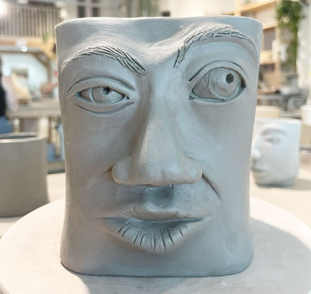 a clay vessel with a face whose eyebrow is raised